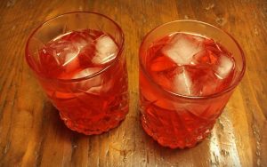 2 rocks glasses with ice, filled with Campari and Aperol cocktails