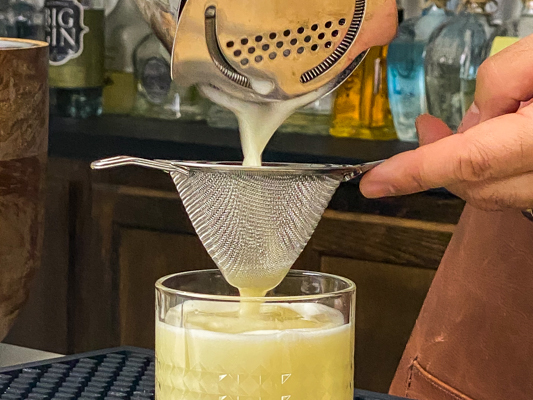 5. Straining drink of the sour family of cocktails into a lowball glass