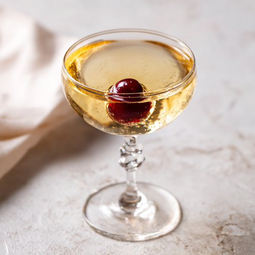 a Manhattan cocktail variation with both dry and sweet vermouth, in a chilled coupe glass with a brandied cocktail cherry