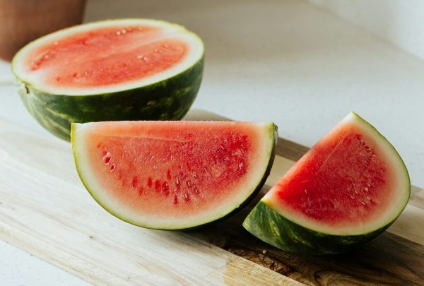sliced watermelon halves on a cutting board