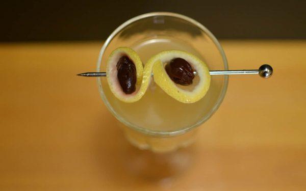 creative cocktail garnishes: piece of peel with cocktail cherries