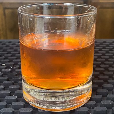 Sazerac cocktail in a rocks glass with ice cubes removed
