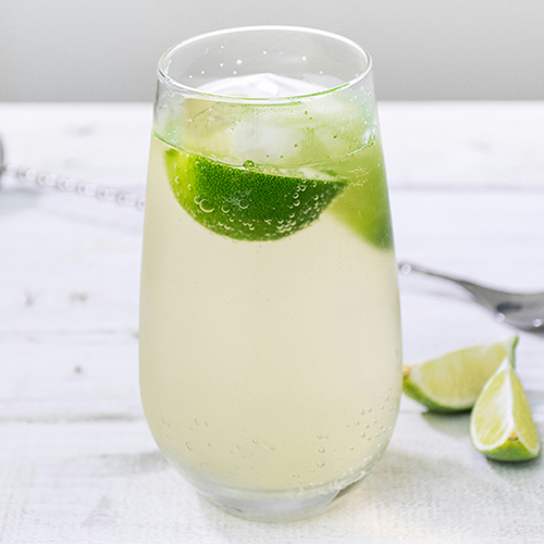 a cocktail with ginger ale and lime wedges