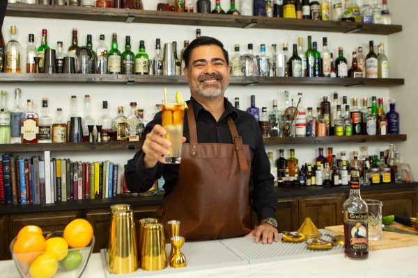 bartender holding a cocktail in a tall glass in a commercial bar