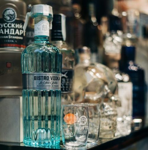 bottles of liquor on a shelf with fashioned glass by gabriella-clare-marino