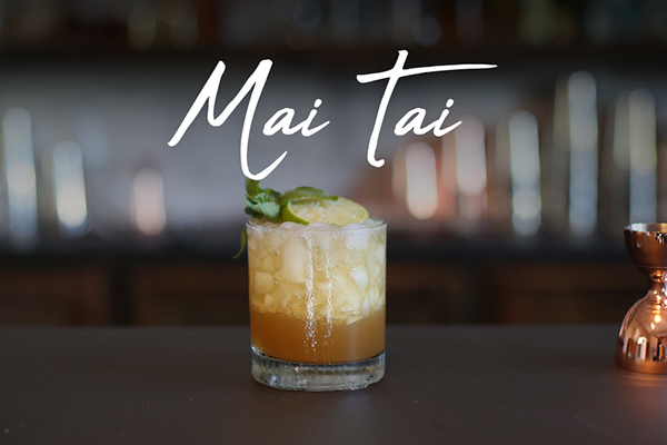 Mai Tai tropical cocktail with simple syrup, 1 ounce dark rum, 3/4 ounce lime juice fresh, and a sprig of mint
