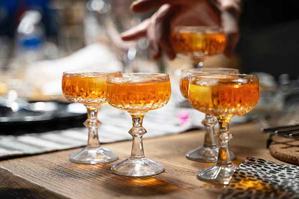 boozy cocktail for cocktail connoisseurs on a bar in fancy coupe glasses by paul einerhand via unsplash