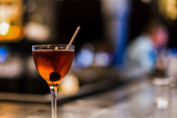 Simple recipe for a Manhattan in a chilled glass on bar by drew beamer via unsplash