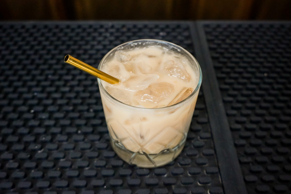 White Russians beige drink on a bar with a bit of cream or full-fat milk