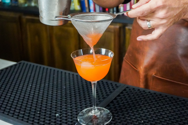 Straining a fruity mocktail for a baby shower