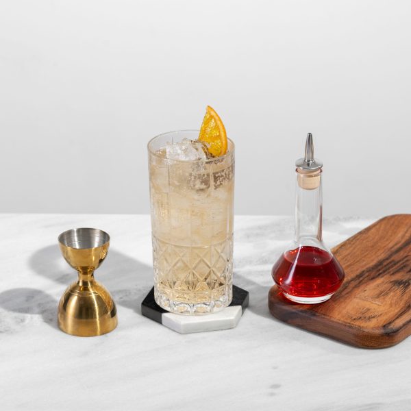10. cocktail with a top choice dasher bottles with red bitters and a piece of barware next to it