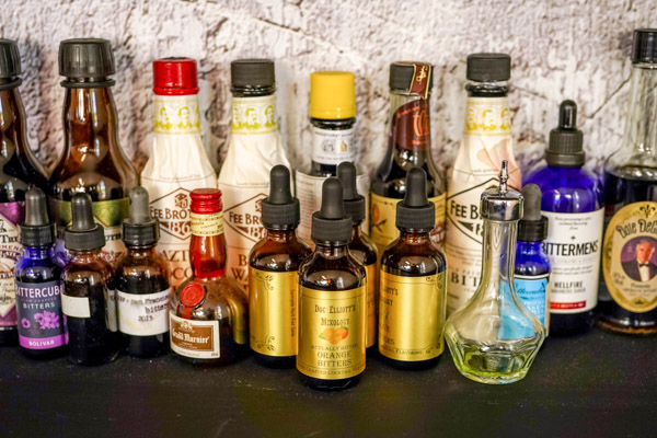5. a row of a wide selection of bottles of quality bitters flavors like black walnut, cherry bitters, chili bitters, and chocolate flavor
