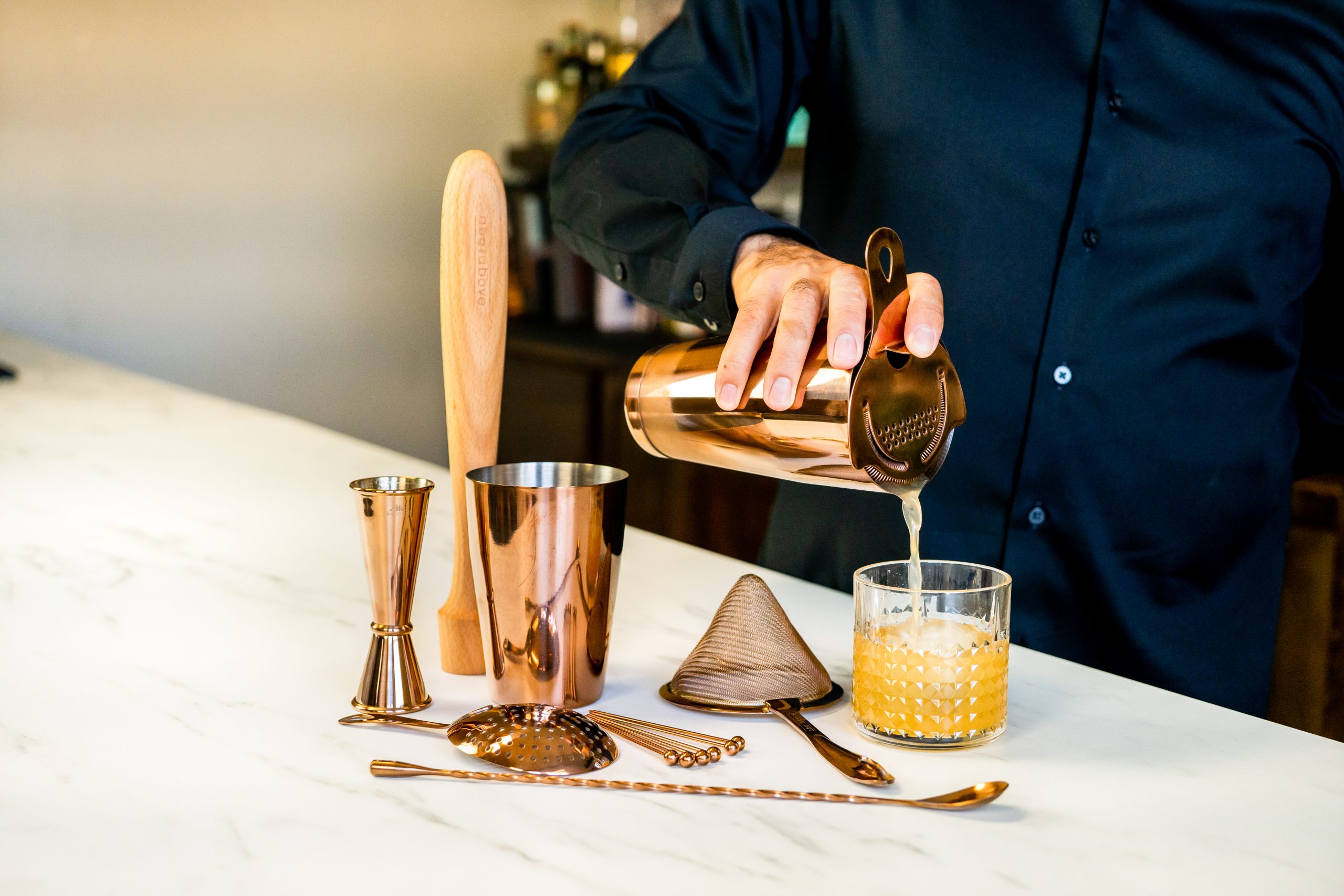 copper gift set on a professional home bar with copper bar spoon and copper cups