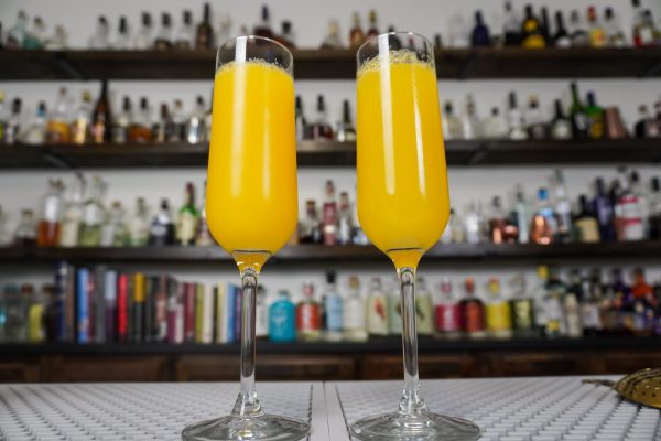 mimosa simple drink in 2 champagne flutes with two-parts champagne