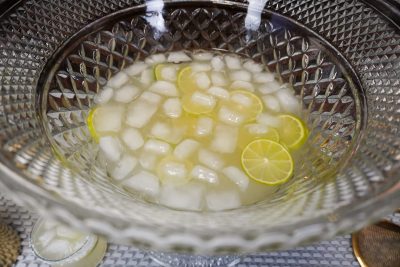 pitcher margaritas in a punch bowl with 1:2 ounce orange liqueur per drink and extra lime slices