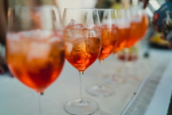 wine glasses lined up with Aperol Spritzes
