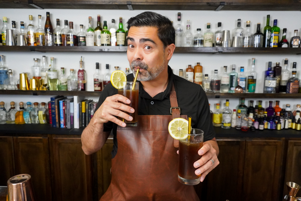 Bartender drinking a finished cocktail with a complex flavor profile