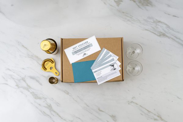 gift kit with 2 coupe glasses (cocktail glasses) and bar tools with recipe cards and a gift card