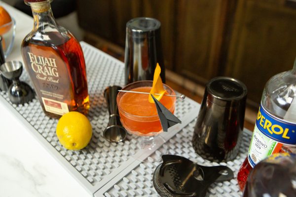 Paper Plane surrounded by bar tools and ingredients