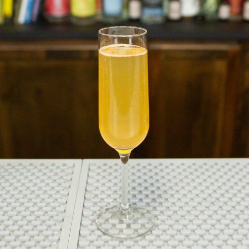 Fresh peach Bellini in a champagne flute on a bar