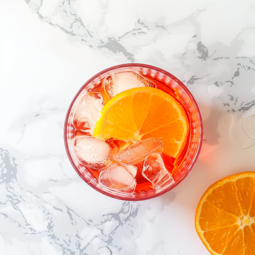 ice-filled glass from top-down on a white countertop, full of Campari with rich flavor