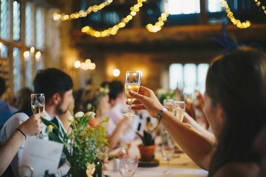 hand holding up a glass of champagne for a wedding toast