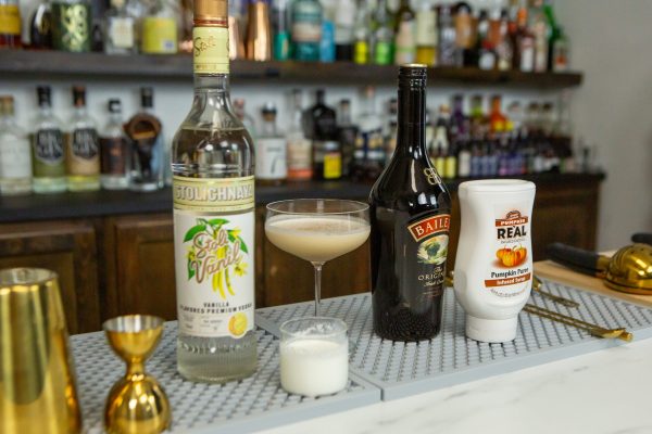 Pumpkin Spiced Martini with its ingredients on a bar