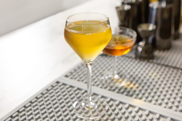 Variation of a Reviver with rum, in a Nick & Nora glass with the original cocktail behind it