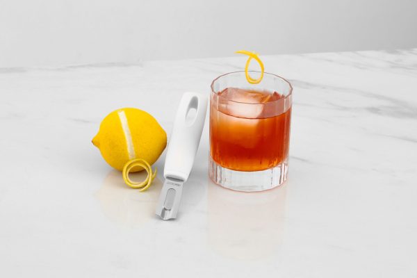a white channel knife with a cocktail and a lemon