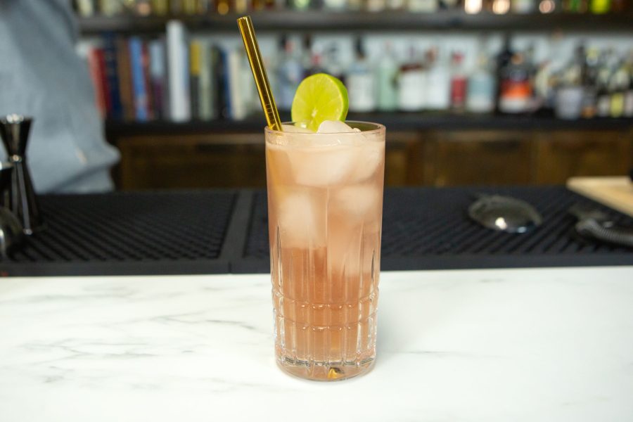 gorgeous reddish purple cocktail in a highball glass with lime wedge garnish