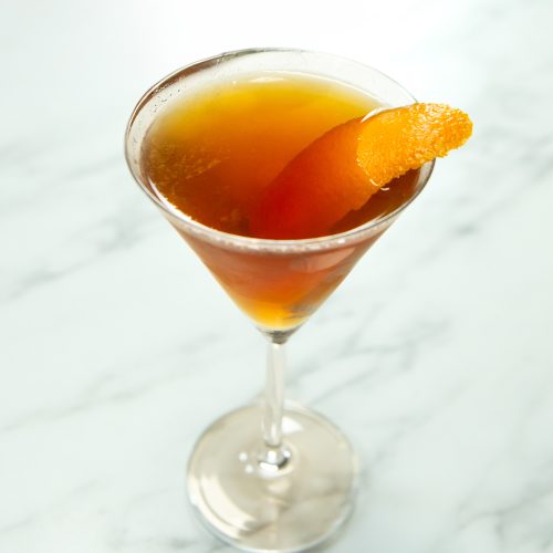 Greenpoint cocktail in a chilled Martini glass with orange peel garnish