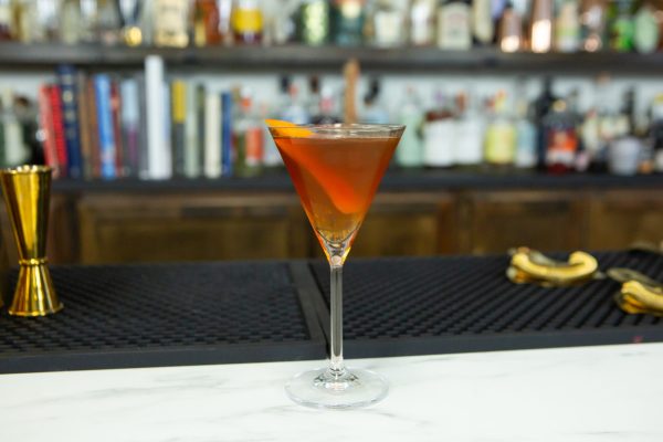 Red-brown cocktail in a Martini coupe on a bar
