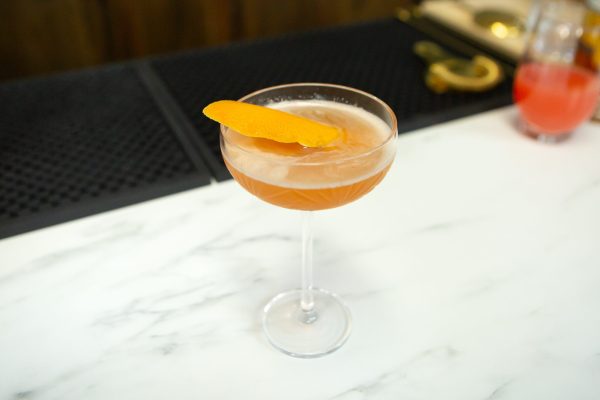 cocktail with a grapefruit peel garnish in a coupe