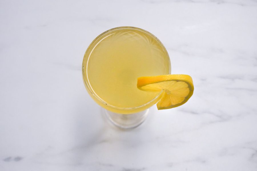 Yellow alcoholic drink with a lemon wheel