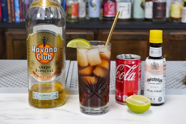 a coke drink with its ingredients: a classic combination of Havana Club rum and Coca-Cola, sitting on a bar