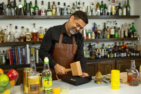 bartender crushing ice in a bar to make a fruity cocktail
