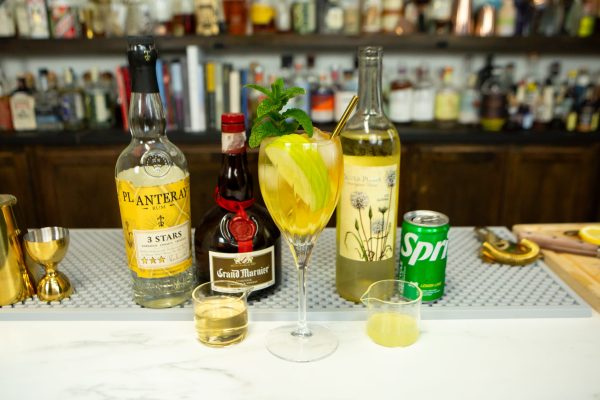 a bottle of wine for sangria on a bar with other ingredients like Sprite, orange liqueur, and white rum