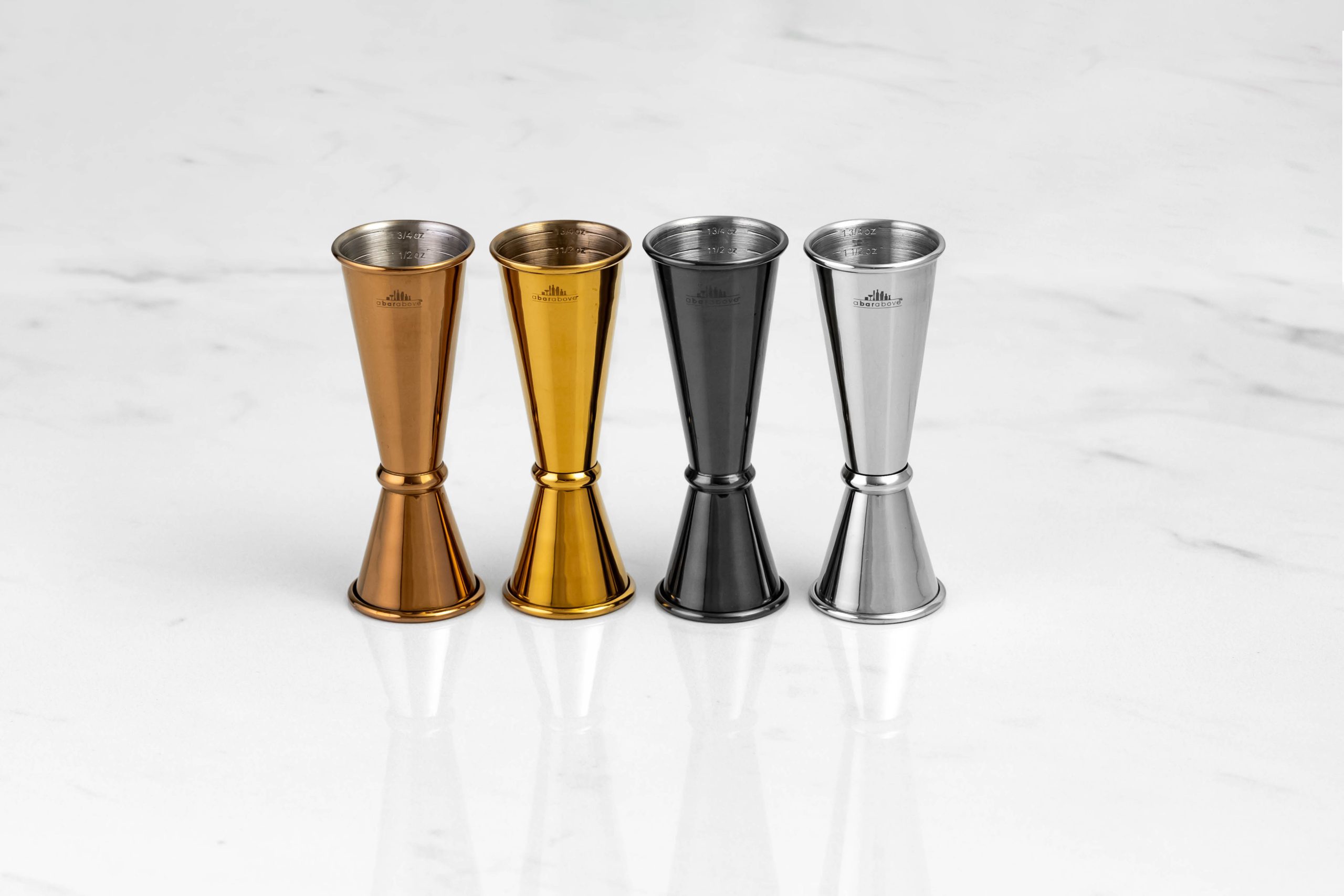 4 Japanese jiggers lined up on a white background, in varying colors: bronze, gold, black, and silver